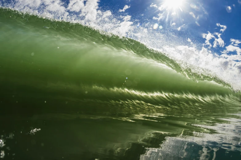 a green wave breaking on the surface of water