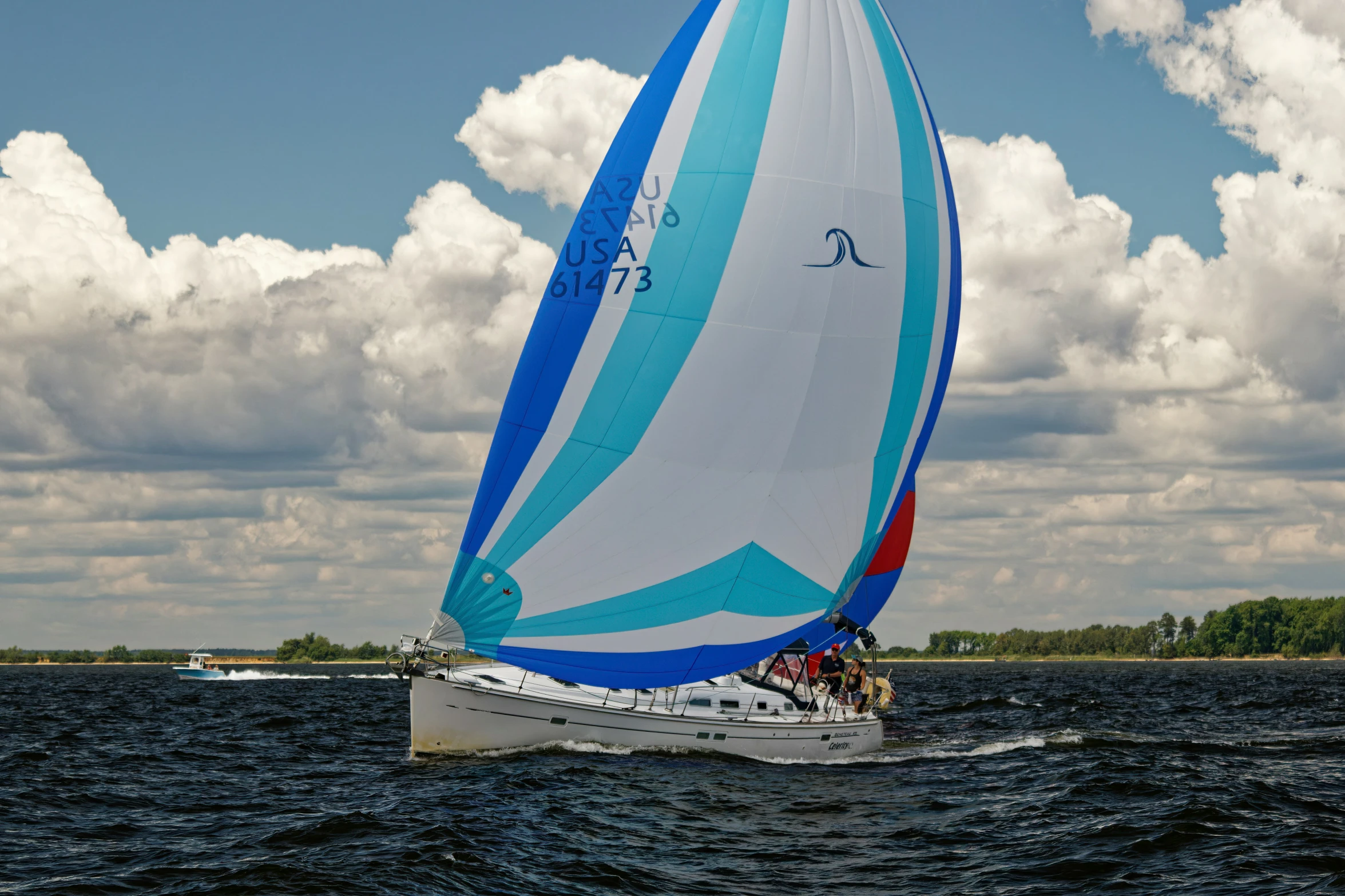 a boat is sailing on the water while clouds hover overhead