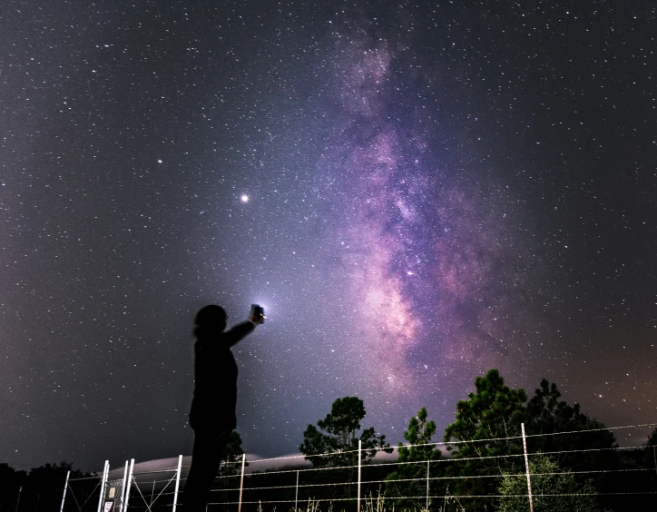 a man looking at the stars above his head