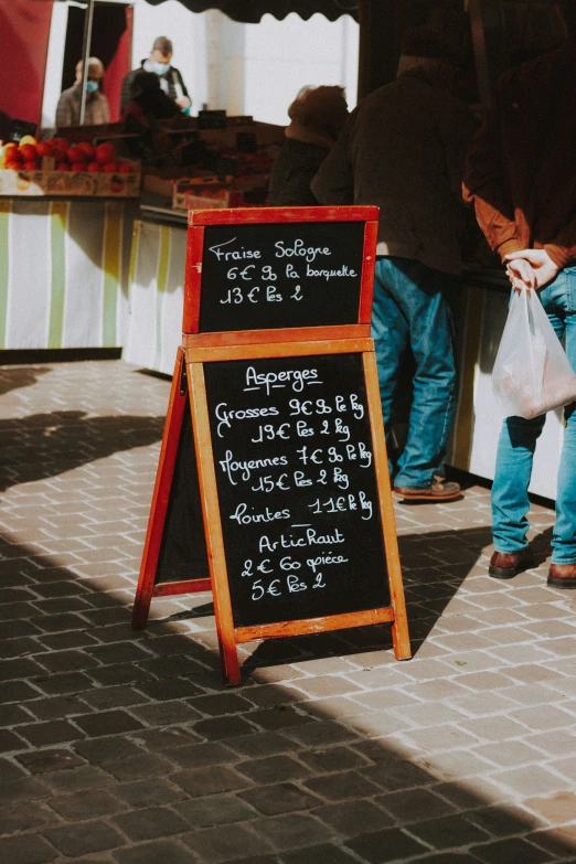 a couple of people near some food and a menu sign