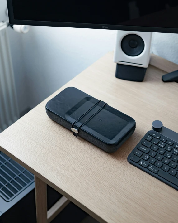 a keyboard, computer mouse and a phone sit on a desk