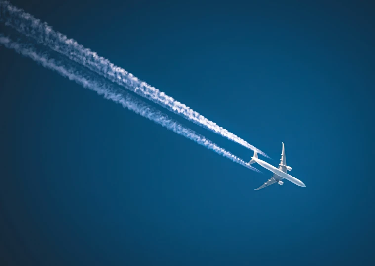 a jet with contrails is flying through the air