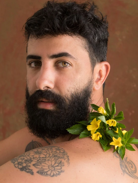 a bearded man with a flower on his chest