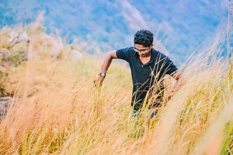 a man is standing alone in a field of tall grass