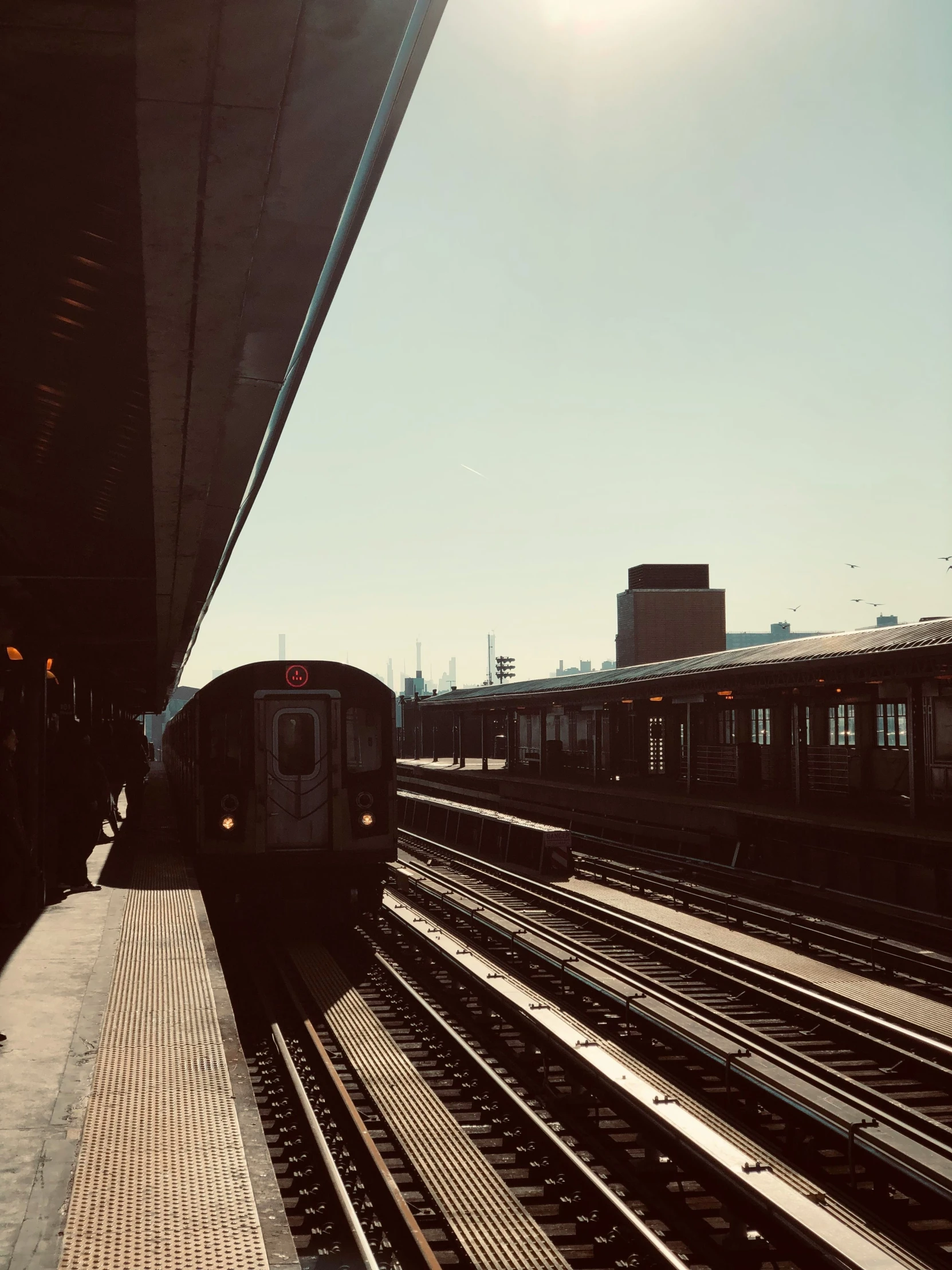 the view from outside of a subway train approaching the platform