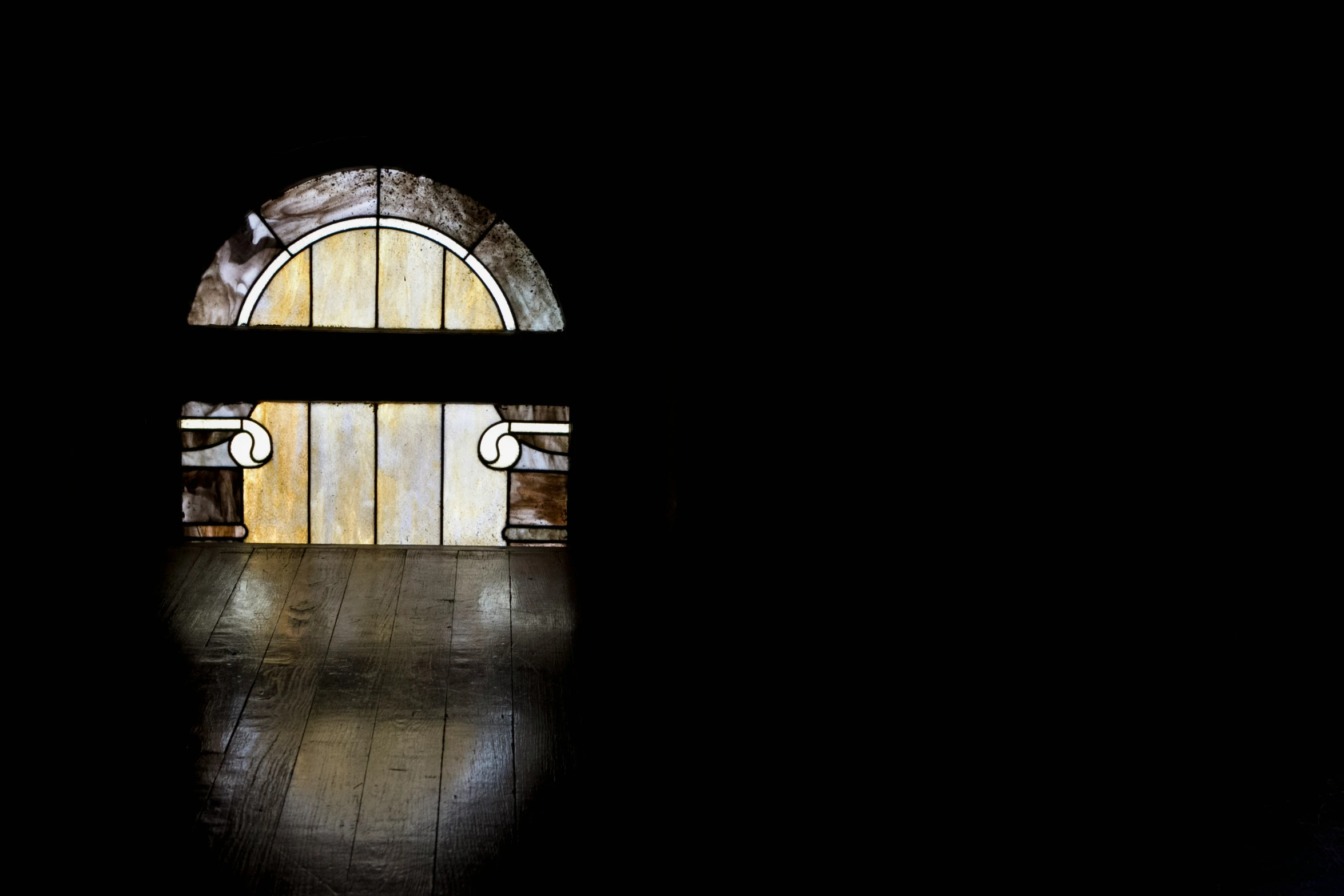 an open door with wood planks and stained glass