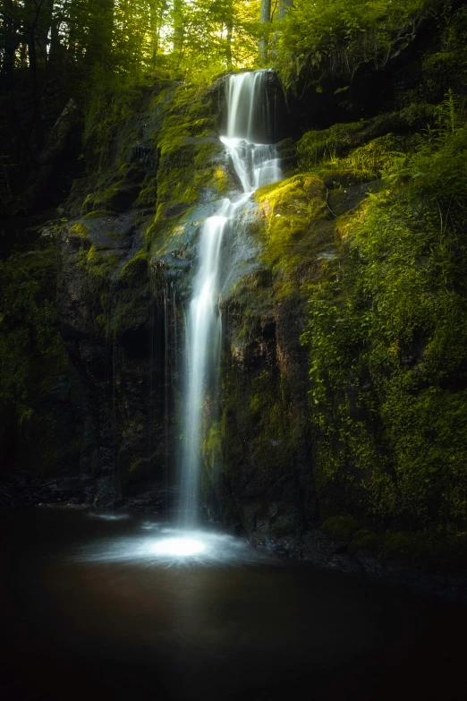 the light from a bright beam is shining onto a waterfall