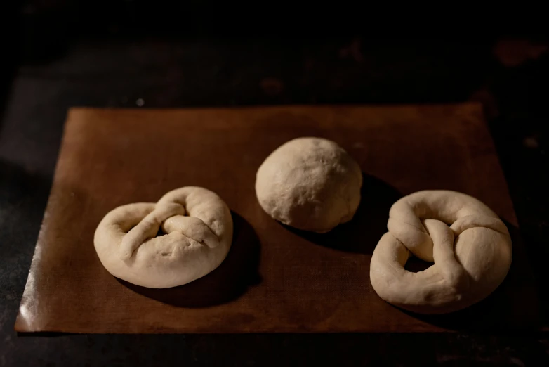 there is three doughnuts on a small wooden board