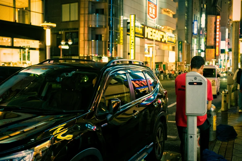 car is parked by a pedestrian crossing booth at night