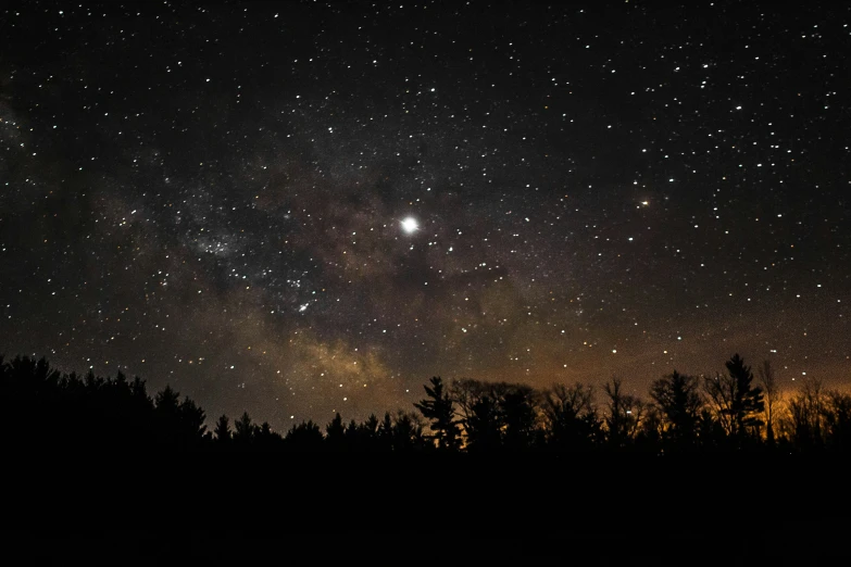 a picture of the night sky with some stars and trees