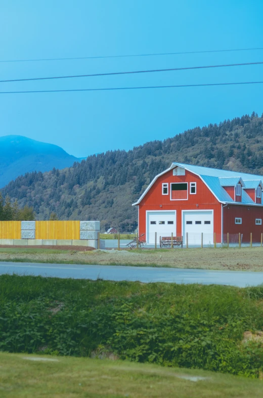 an image of a small red barn with a farm house on top