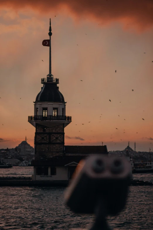 a building with a clock tower on top next to some water