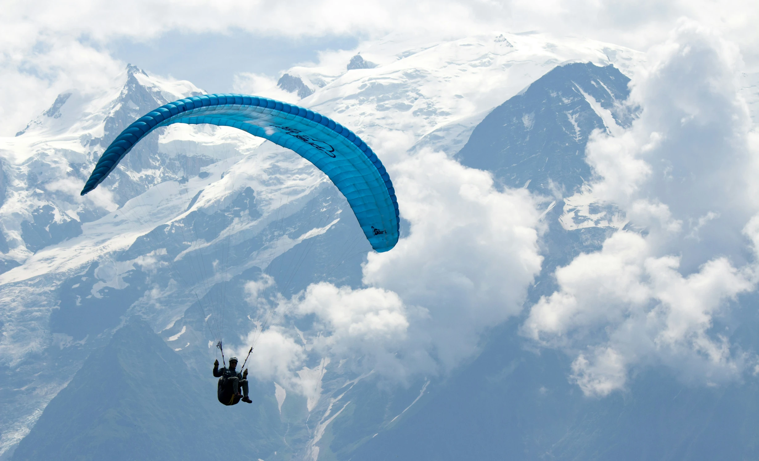 parasailers in the sky over some mountains