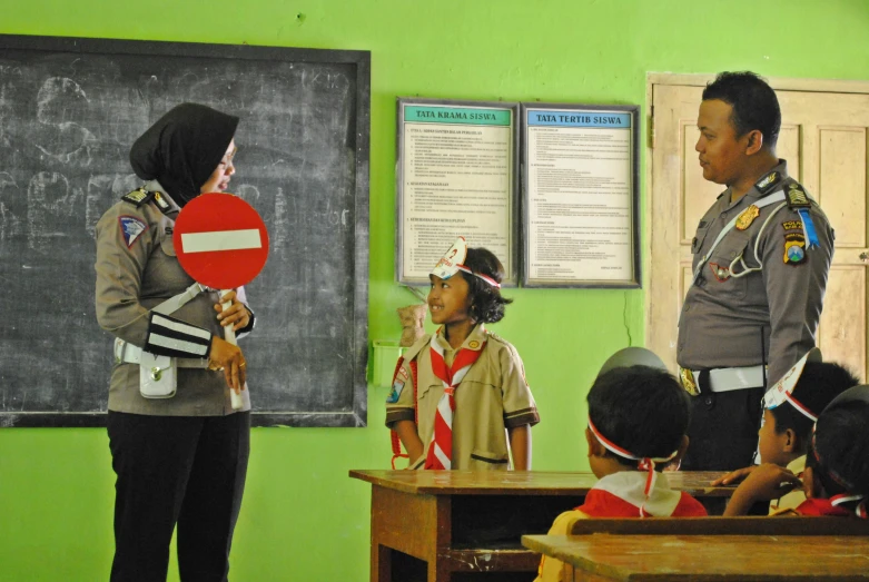 a blackboard is in the background of a group of s sitting at desks