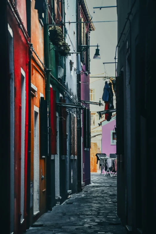 a narrow street with a sign in between two buildings