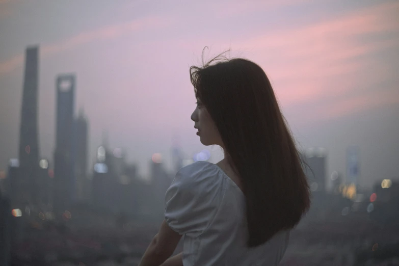 a young woman looking at a skyline at sunset