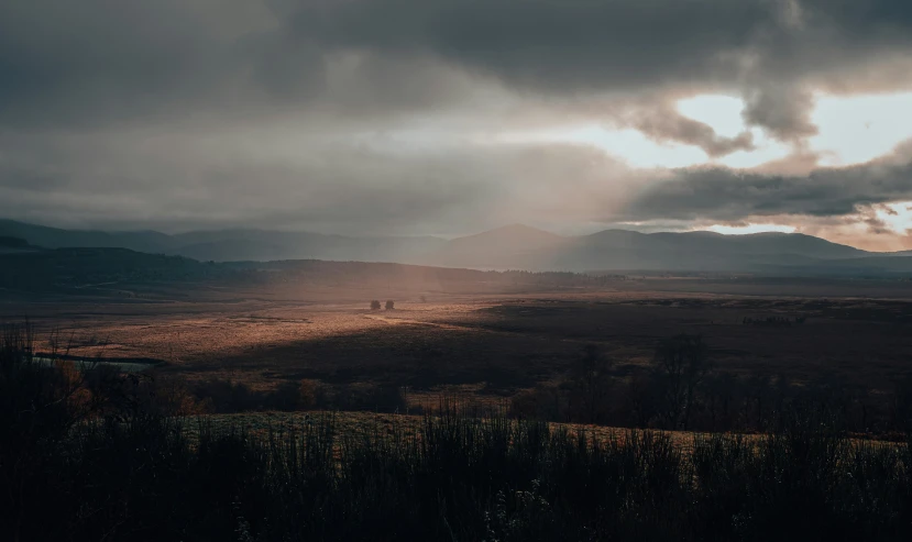 a stormy sky is shown with a sun shining down on the valley