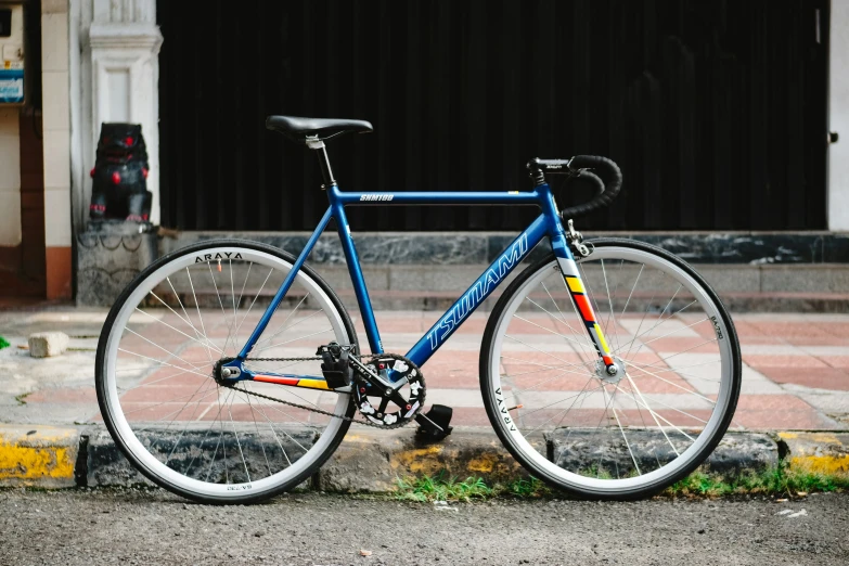 a blue and black bike is parked on the sidewalk