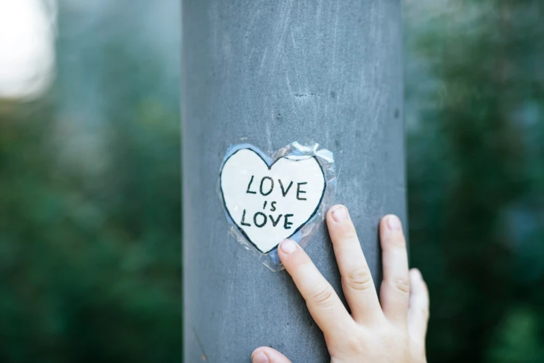 a sticker attached to a pole that has a broken heart on it