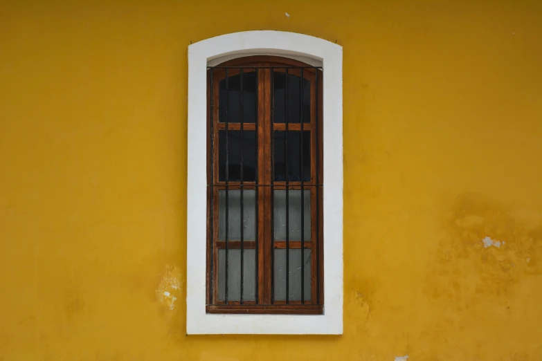 an open window is seen on the yellow wall