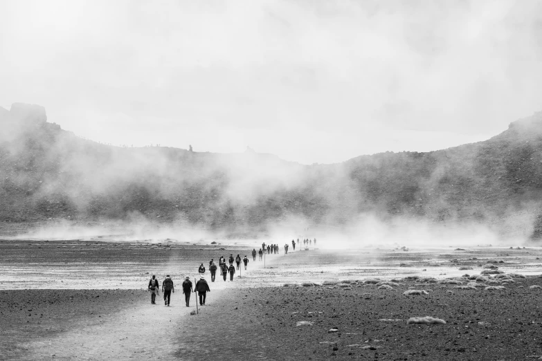 a large group of people walking along a beach