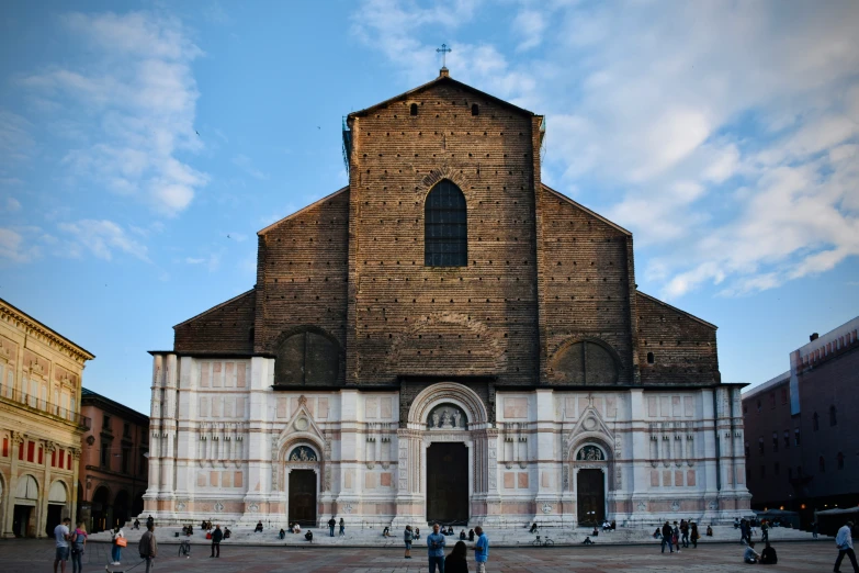 people walk near an old church with a sky background