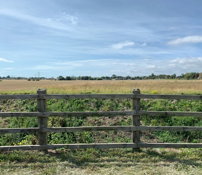 an empty field with a fence in the foreground