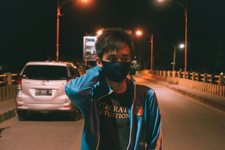 a man wearing a mask on the street at night