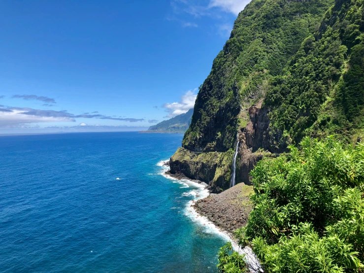 a scenic ocean and mountain scene with clear blue skies