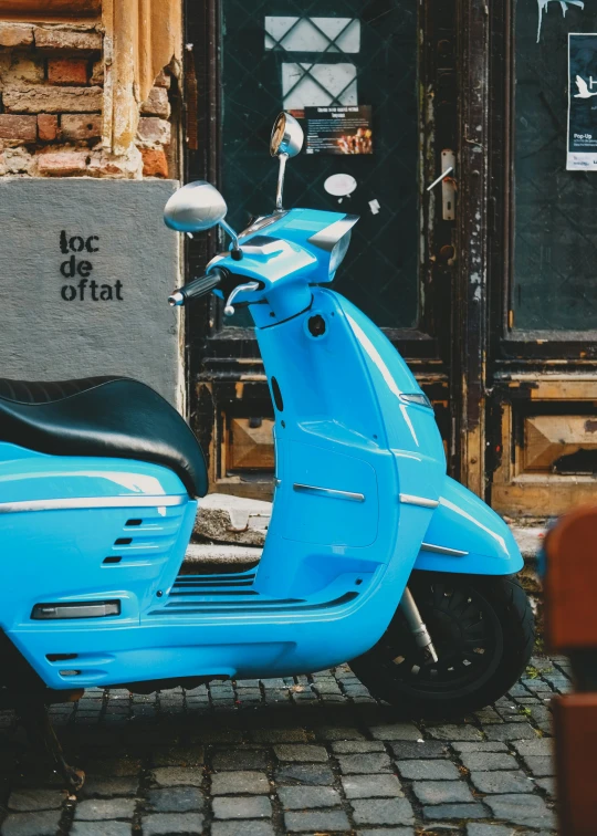 an image of a blue scooter parked in front of a building