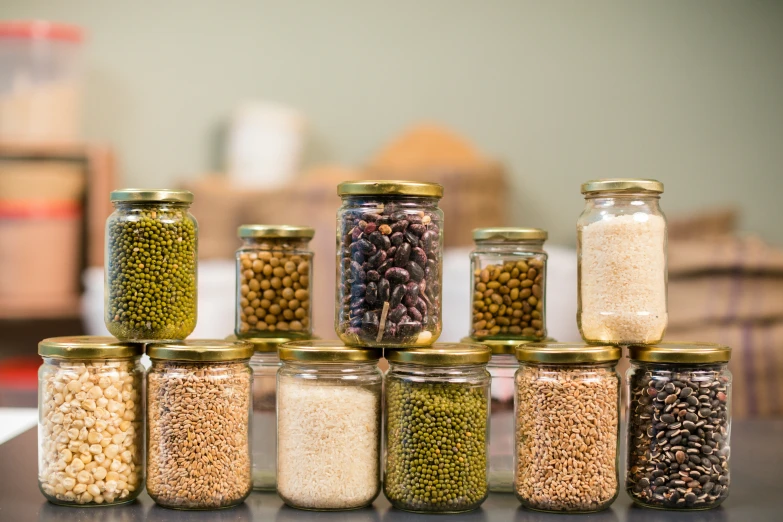 five jar with various grains on top of it