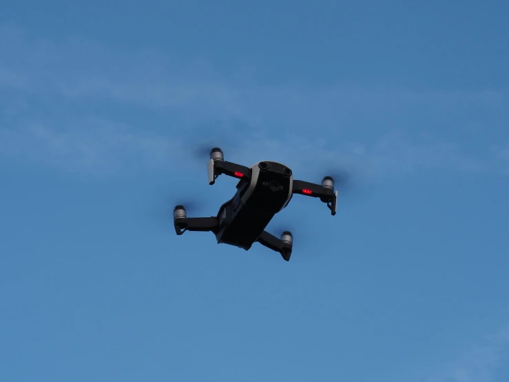 a small black device in the sky, flying upside down