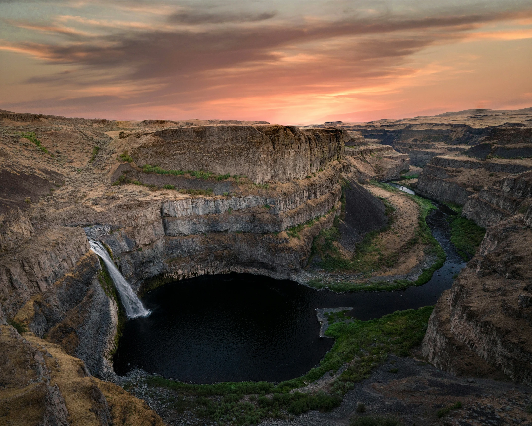 a beautiful landscape with water surrounded by a cliff