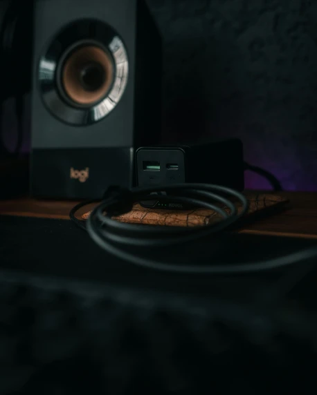a speaker and cords are on a desk