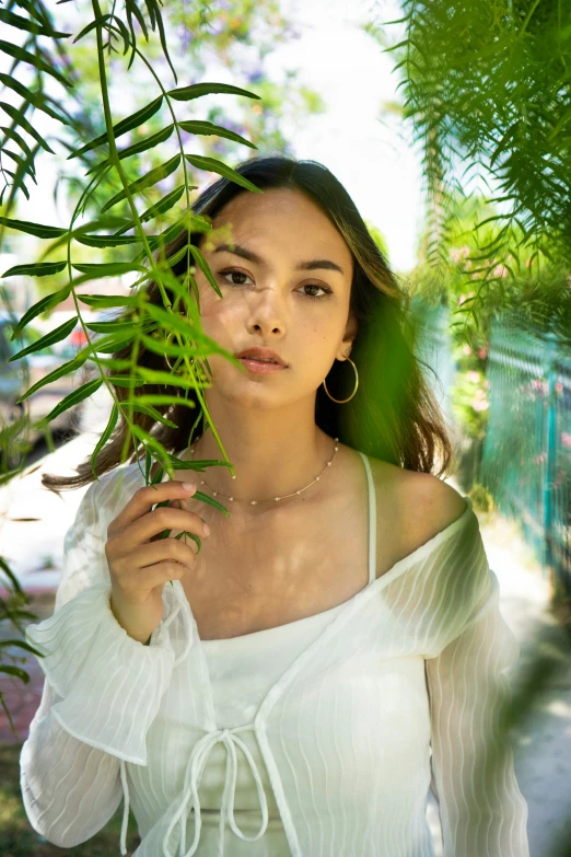 an asian model in white top and tropical foliage