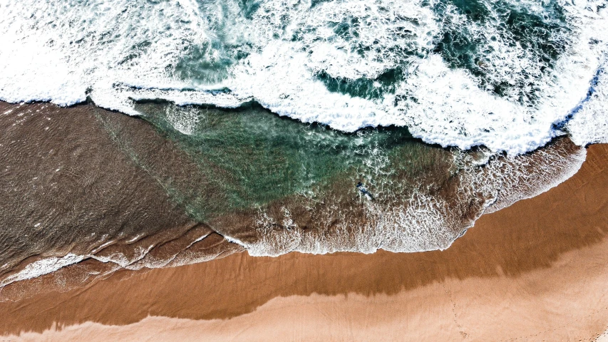 top down view of an ocean and sandy beach