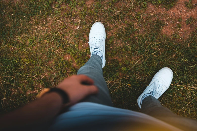 the shoes of a person wearing pants and a sweater