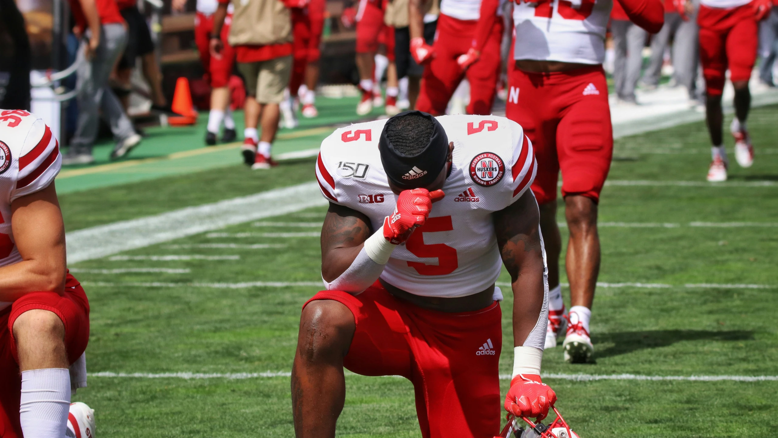 the football player in red is kneeling on the field