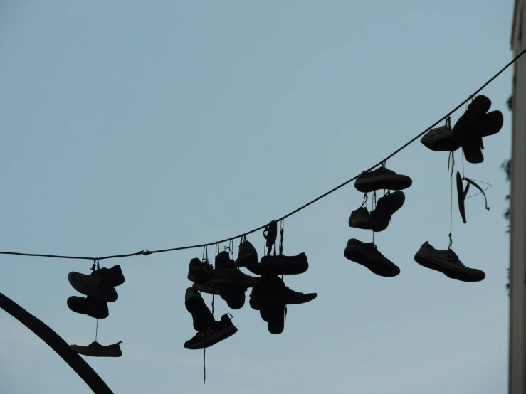 several shoes are hanging in the air between a line of string