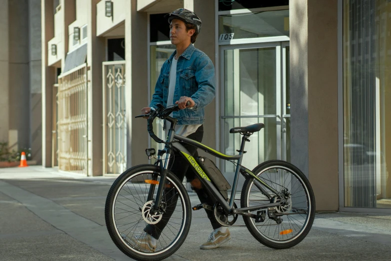 a man is carrying his bicycle down the street