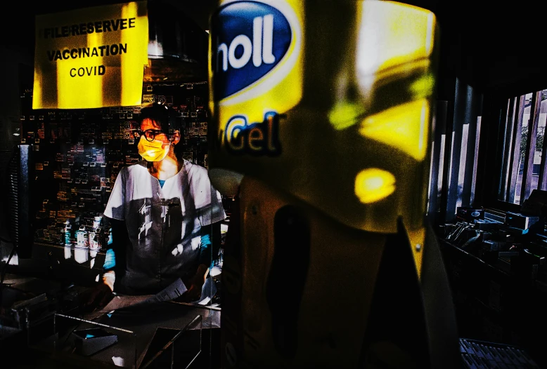 a woman wearing shades next to a sign in a room