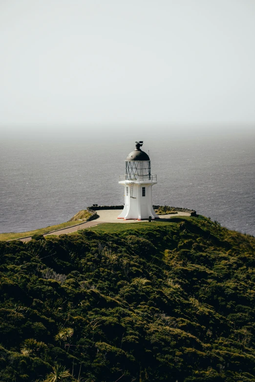 a lighthouse on top of a grassy hill