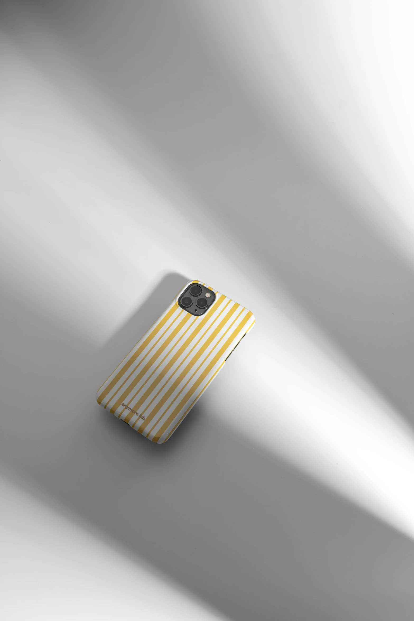 a white phone with a yellow and white striped cover