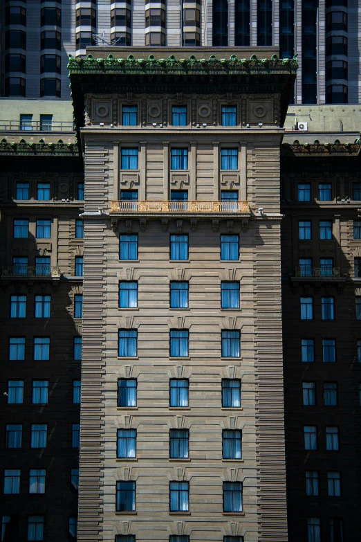 this is a building with multiple windows and green vegetation growing on it