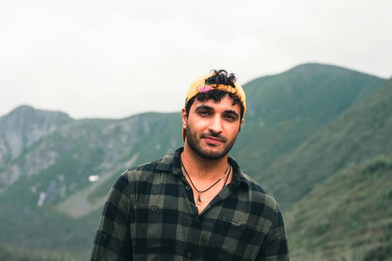 a man is posing for a picture wearing a flannel shirt