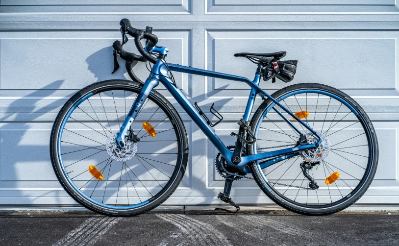 a blue bike that is next to a garage door