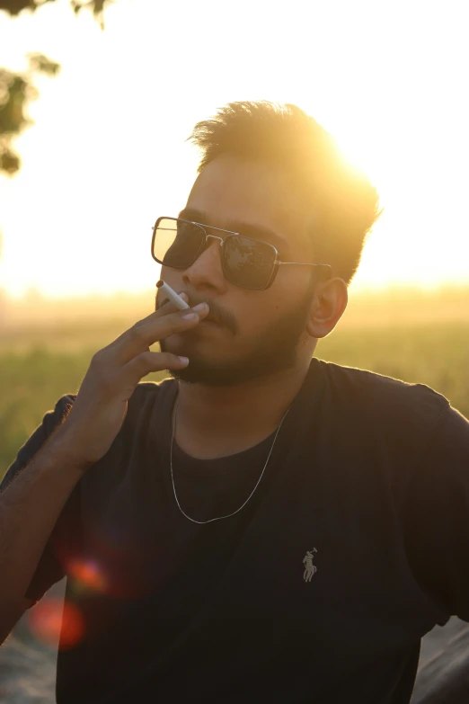 a man wearing glasses smokes a cigarette outside