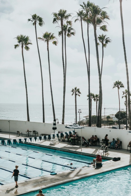 swimmers are gathered around a big swimming pool