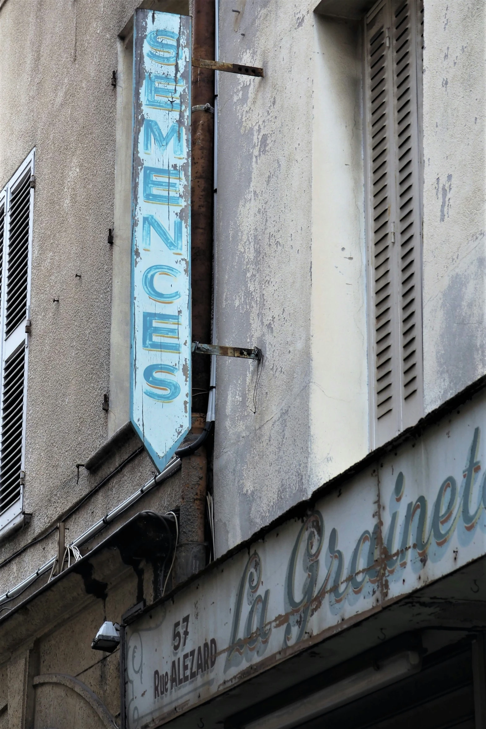 the neon sign hangs off the side of an old store