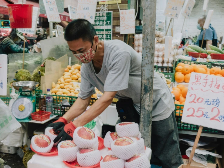 the man with black gloves is  apples